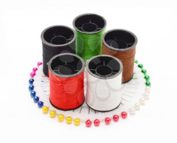 Set of color sewing threads on colorful sewing pins wheel over white background.