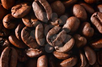 Roasted coffee beans full frame background. Macro shot of coffee beans with visible texture.