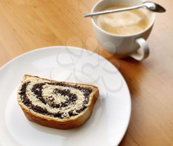 Top View of Poppy Seed Roll Slice with Cup of Coffee on the Wooden Table.