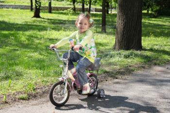 young girl riding bicycle in park