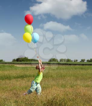 little girl running with colorful balloons