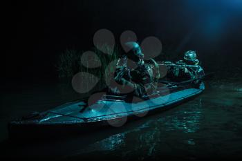 Two special forces soldiers in the military kayak. Diversionary mission under cover of darkness