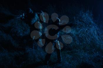 Commandos group, army special operations tactical group, military patrol team marching in field loaded with ammunition, sneaking in darkness, carefully and quiet moving in line during night mission