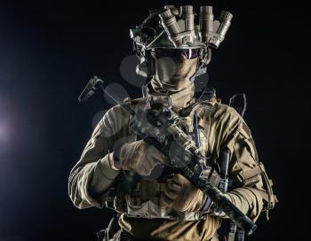 Elite commando fighter, private military company mercenary, special operations serviceman, security or secret service shooter equipped modern weapons and ammunition, studio shoot on black background