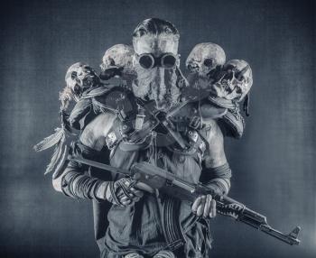 Post apocalyptic survivor, radioactive zone stalker, crazy serial killer or maniac in glasses and skulls on shoulders, with automatic rifle