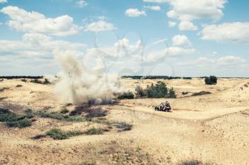 Large explosion near the car with soldiers in the desert