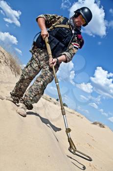 iraqi soldier in the desert with army metal detector