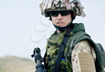 soldier in desert uniform holding his rifle