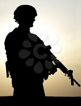 Silhouette of US soldier with rifle against a sunset