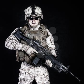 US marine with his assault rifle on black background