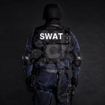 Special weapons and tactics (SWAT) team officer on black background shot from behind