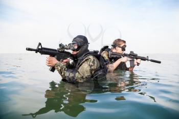 Navy SEAL frogmen with complete diving gear and weapons in the water