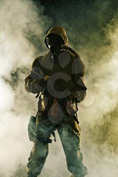 Nuclear post apocalypse. Studio shot of survivor with weapons and gas mask