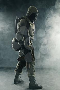 Nuclear post apocalypse. Studio shot of survivor with weapons and gas mask