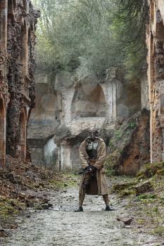 Nuclear post-apocalypse. Sole survivor in tatters and gas mask on the ruins of the destroyed city
