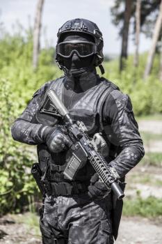 Spec ops police officer SWAT in black uniform in action