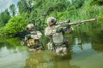 Navy SEALs crossing the river with weapons 