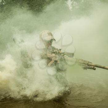 Member of Navy SEAL Team crossing the river with weapons