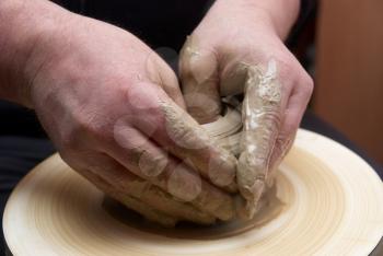 Female hands forming clay pot on the pottery wheel 