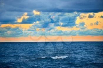 Big wave, colorful sunset over the sea with blue sky and clouds