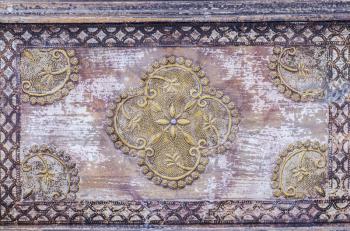 Beautiful antique indian furniture. Old wooden pattern texture. Vintage furniture with ornament. Oriental design, wooden decor.Chopping mandala made of brass.