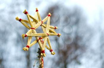 Straw star, isolated on blurred background. Christmas tree decoration made of straw.