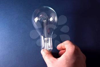 Incandescent lamp in the hand. Lamp is the source of lighting.