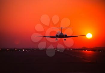Takeoff of a passenger plane on the background of a sunset. Flight of the air liner at sunset.