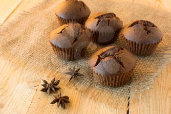 Chocolate muffins on sackcloth and anise, selective focus