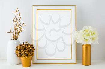 Frame mockup with ivory hydrangea in the  golden vase, white vase and golden flower pot. Poster white frame mockup. Empty white frame mockup for presentation artwork.