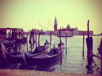 Moored gondolas in Venice, vintage toned. Gondolas moored by Saint Mark square. View of the San Giorgio di Maggiore from Piazza San Marco. Venice, Venezia, Italy, Europe.