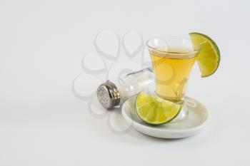 Glass of tequila with lime on the white background. Tequila shot. Gold Mexican tequila. Tequila