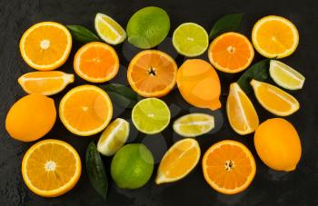 Lime, lemon, orange and tangerine on black background. Fresh food. Ripe fruit. Citrus fruit. Vegetarian food. Mixed fruit. Fresh fruit.