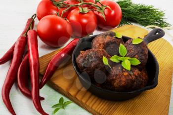 Grilled meatballs with chili pepper served in skillet. Grilled bbq meatloaf. Barbecue meatballs. 