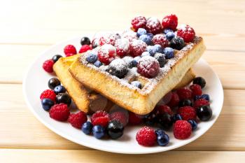 Soft waffles with blueberry and raspberry. Breakfast soft waffles with fresh berries. Belgian waffles.