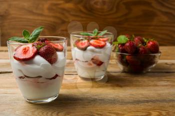 Strawberries cream cheese dessert on wooden background. Whipped cream with fresh strawberry.