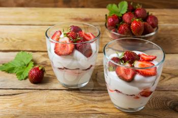 Summer layered cream cheese dessert and strawberry in glass bowl . Whipped cream with fresh strawberry. 