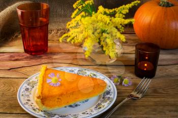 Thanksgiving pumpkin pie slice on the old wooden table. Traditional Thanksgiving pumpkin pastry. Squash pie slice