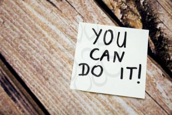 You can do it motivational handwritten message on the white paper with retro wooden bark background. Positive and motivational message written on white paper.