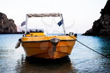Yellow boat sailing in river in Corfu Greece. Blue clean water. Beautiful landscape. Ship crossing water through cliffs. Traveling adventures. Relaxation on boats