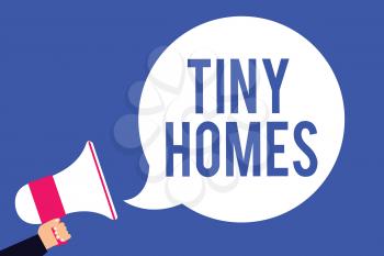 Text sign showing Tiny Homes. Conceptual photo houses contain one room only or two and small entrance Cheap Man holding megaphone loudspeaker speech bubble screaming blue background