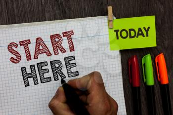 Conceptual hand writing showing Start Here. Business photo text telling someone this is beginning point to go from to destination Man holding marker notebook clothespin markers wooden table