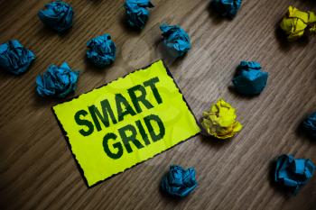 Word writing text Smart Grid. Business concept for includes of operational and energy measures including meters Yellow piece paper reminder lots crumpled papers several tries wooden floor