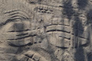 Footprints of shoes on forest sand close-up