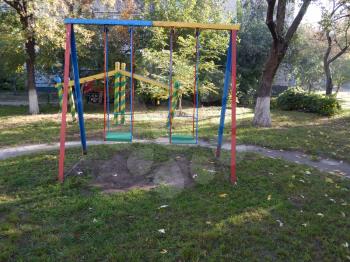 Children playground, swing near the house