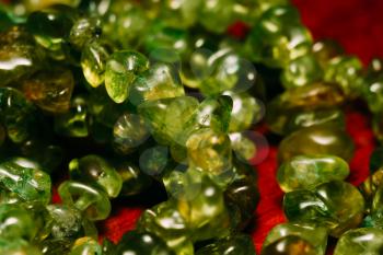 August birthstone olive green peridot, natural stone gravel close up.