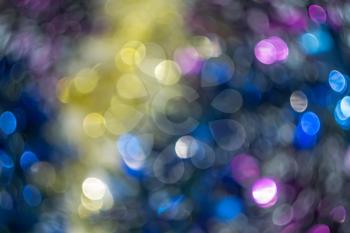 Defocused decorative Christmas tinsel as background with bokeh effect.