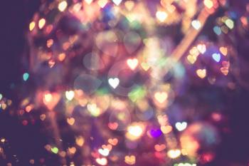 Festive background with heart shaped bokeh from Christmas tree lights glowing. 