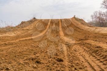 Trail of treads on a sandy quarry background.