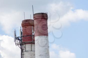 Old industry smoke stack over sunny blue sky.